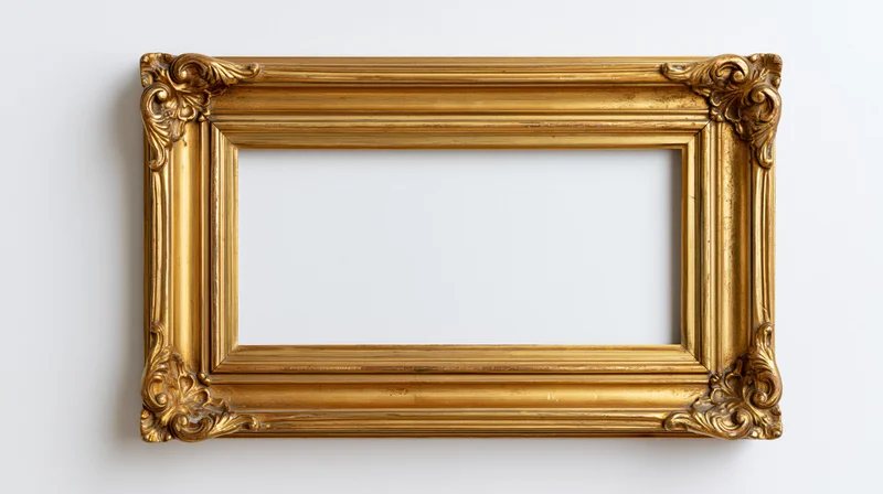 Ornate gold picture frame with carved corners hanging on white wall