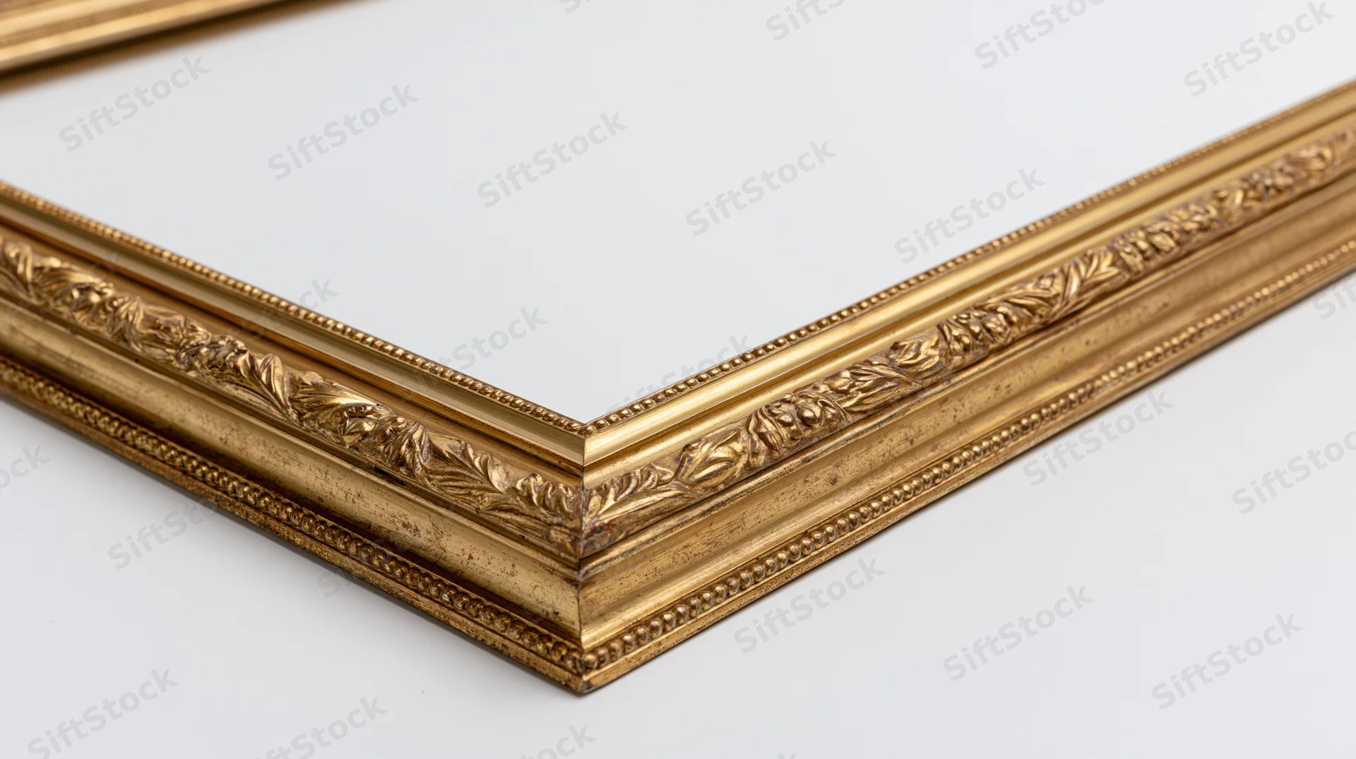 Ornate antique gold picture frame corner lying flat on white background