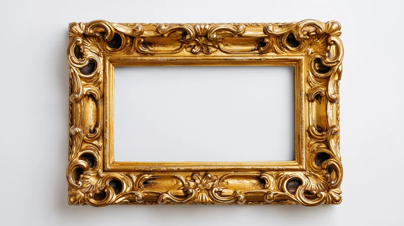 Ornate gold antique frame with baroque scrollwork hanging on white wall