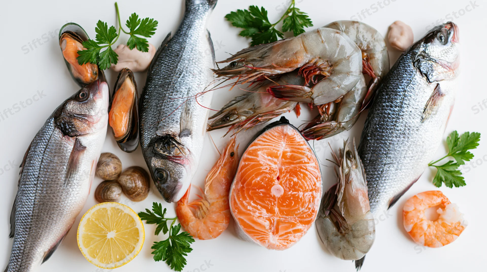 Assorted fresh raw seafood arranged on white surface with lemon and parsley