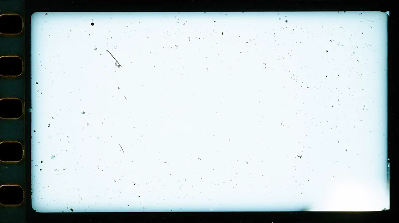 Overexposed blank 16mm film frame with speckles and sprocket holes on black background