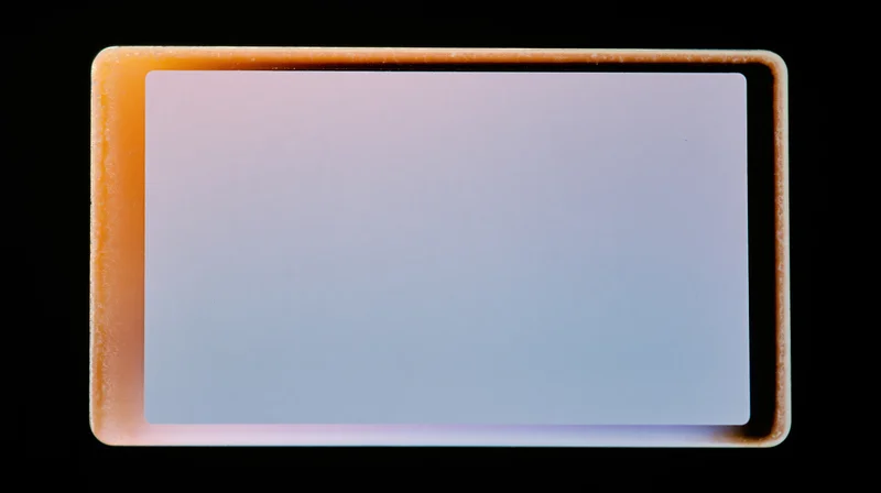 Blank overexposed analog film frame with orange border on black background