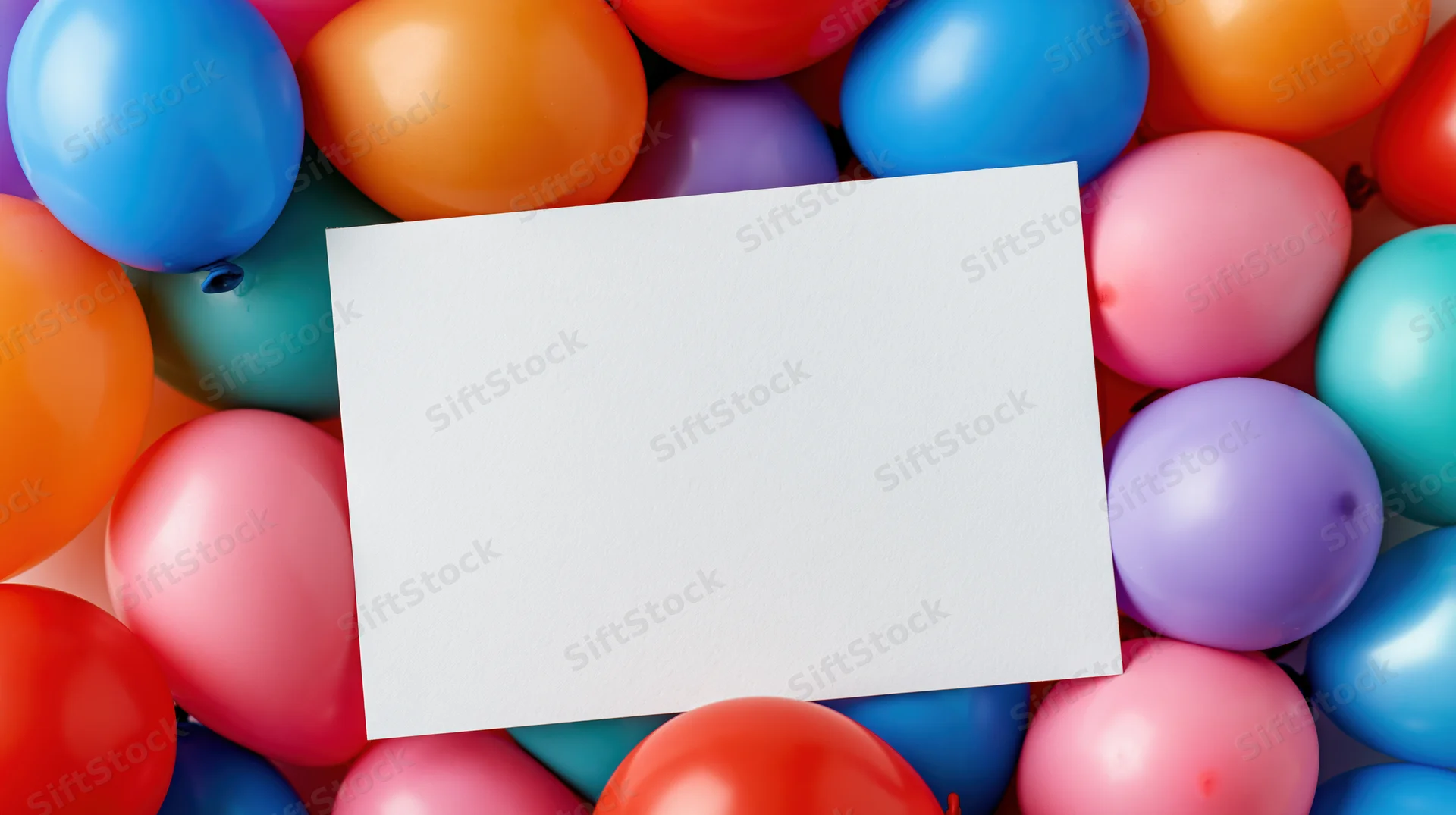 Blank white card surrounded by colorful balloons for party decoration