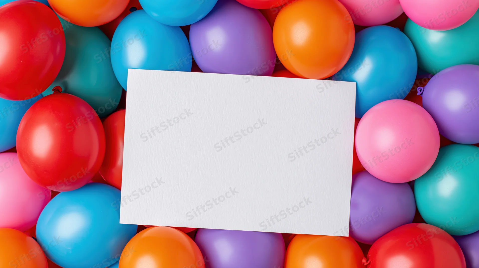 Blank white card surrounded by colorful balloons for party decoration