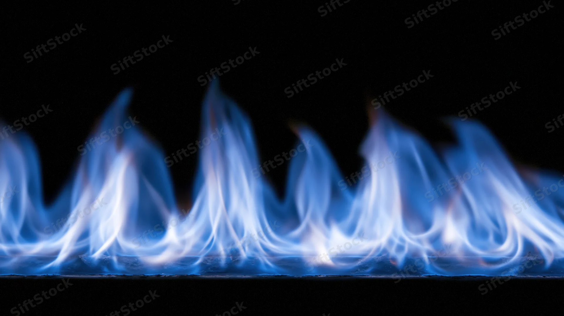 Blue gas flames burning low across the bottom of the frame against a black background