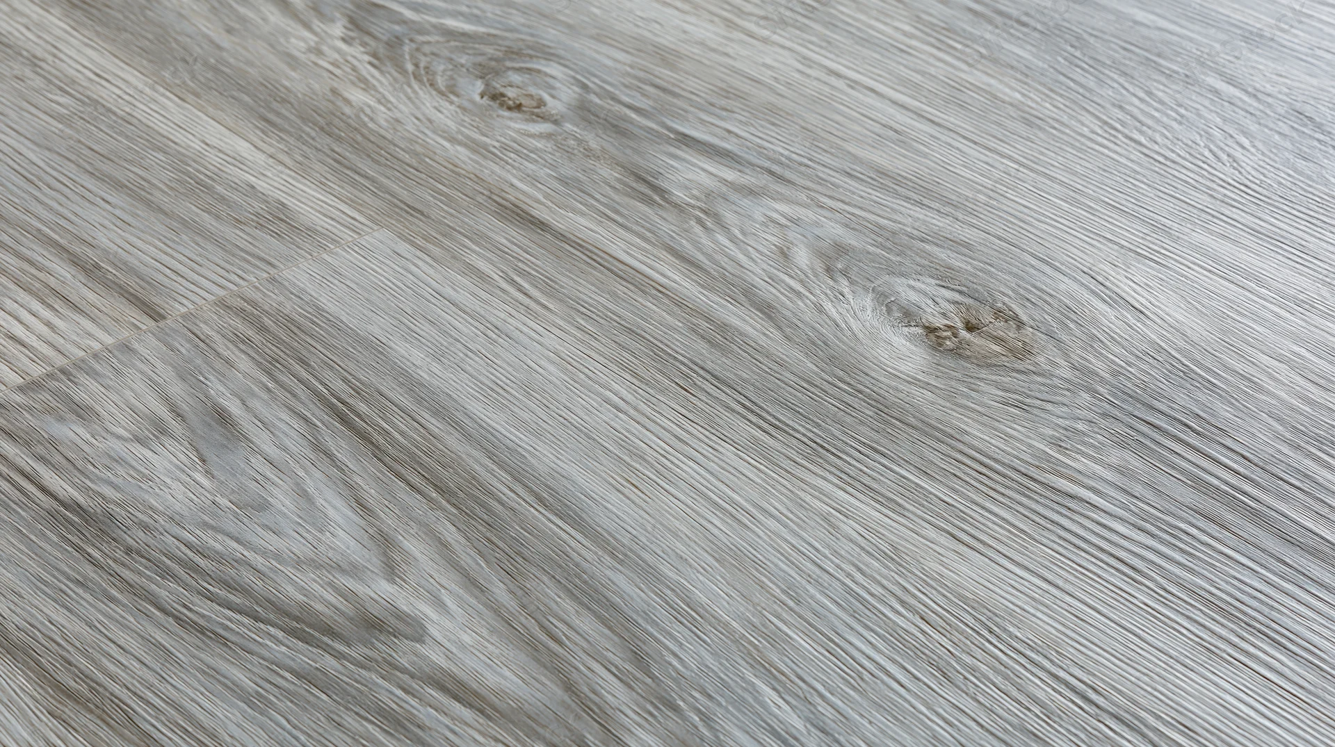 Diagonal closeup of grey laminate wood-effect flooring surface