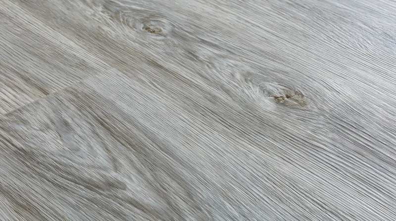 Diagonal closeup of grey laminate wood-effect flooring surface