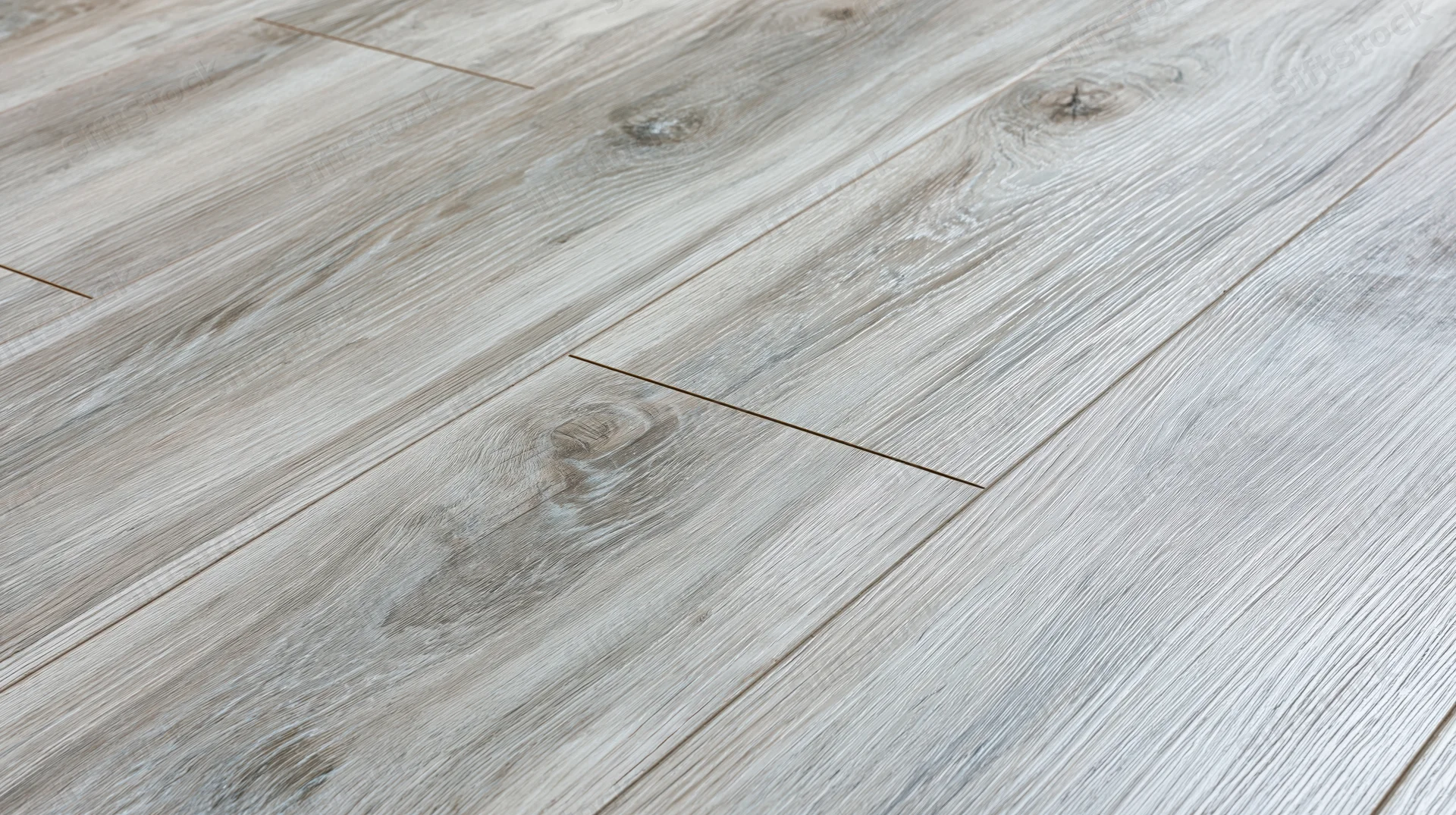 Diagonal close-up of grey laminate wood-effect flooring planks