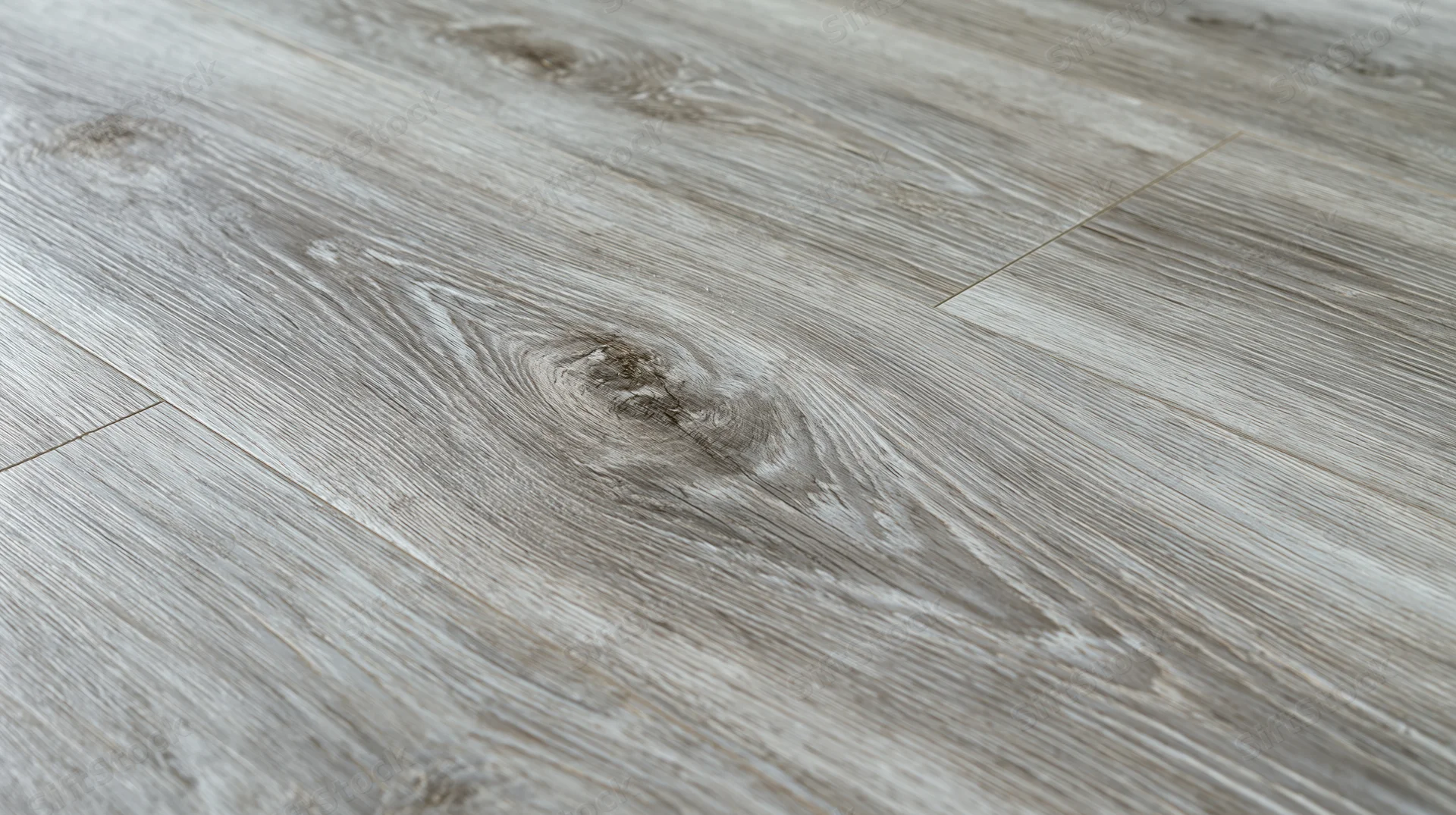 Close-up diagonal view of grey laminate wood-effect flooring surface