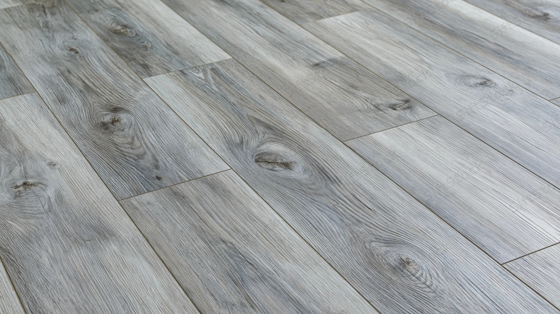 Diagonal close-up of grey laminate wood-effect flooring planks in an interior space