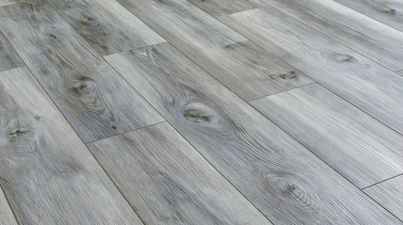 Diagonal close-up of grey laminate wood-effect flooring planks in an interior space
