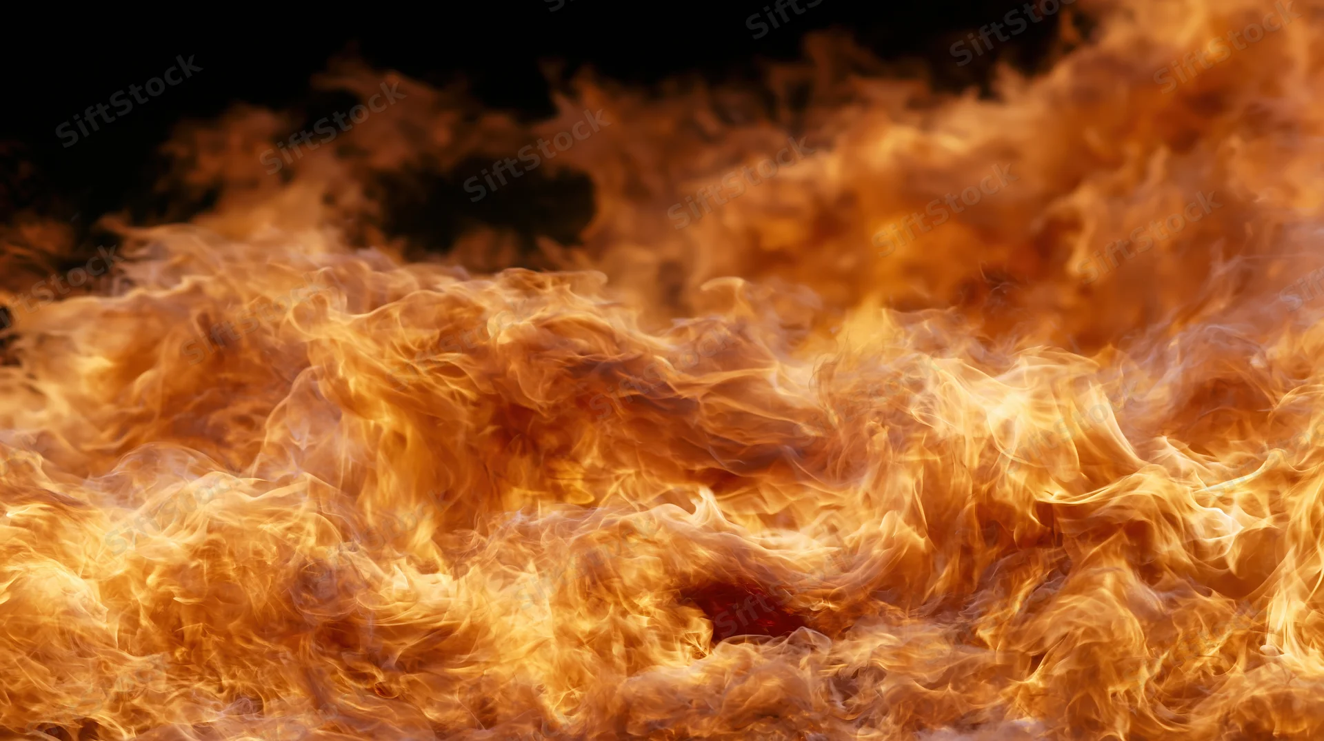 Intense flames burning dynamically across the frame with bright orange and yellow hues