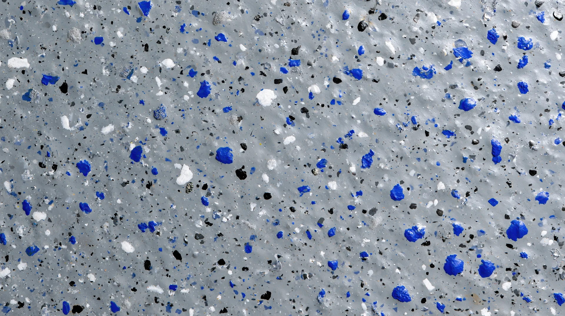 Close-up of a grey epoxy-coated concrete floor with blue, white and black speckles
