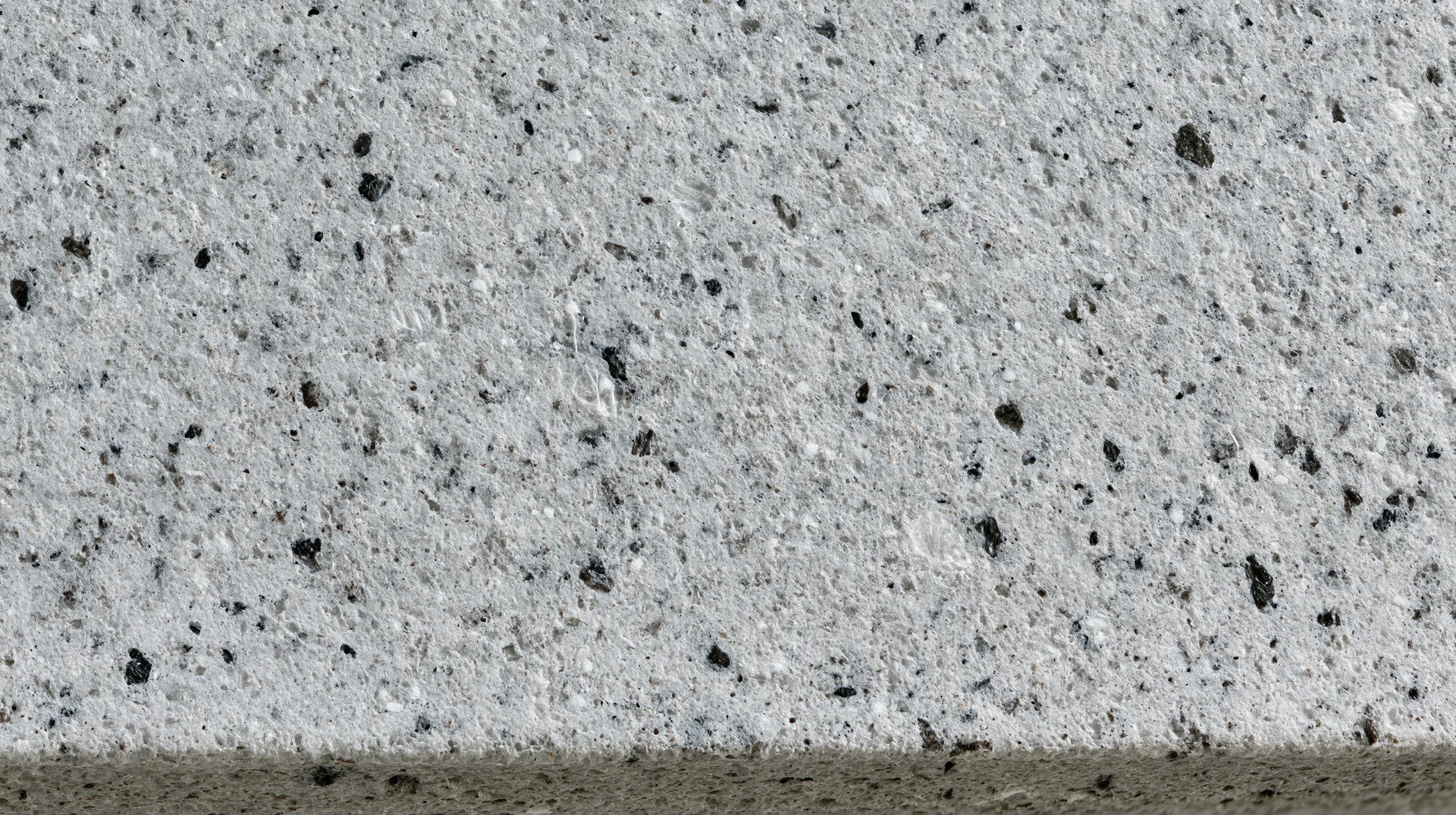 Close-up of polished concrete surface with embedded aggregate speckles