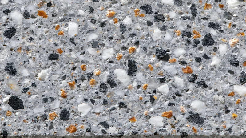 Close-up of polished terrazzo floor surface with gray matrix and black white orange aggregate specks
