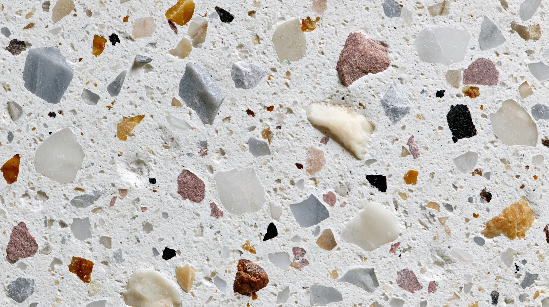 Close-up of terrazzo floor surface with embedded stone chips in white matrix