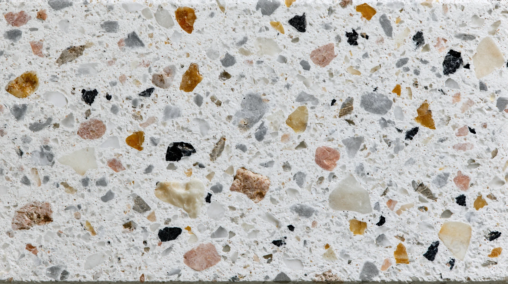 Close-up of terrazzo floor surface with embedded stone chips in white matrix