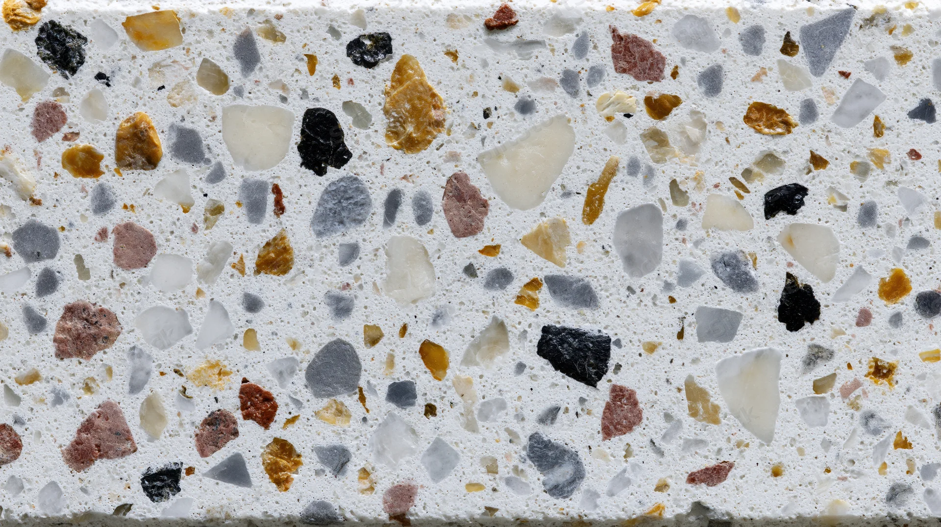 Close-up of terrazzo floor surface with embedded stone chips in white matrix