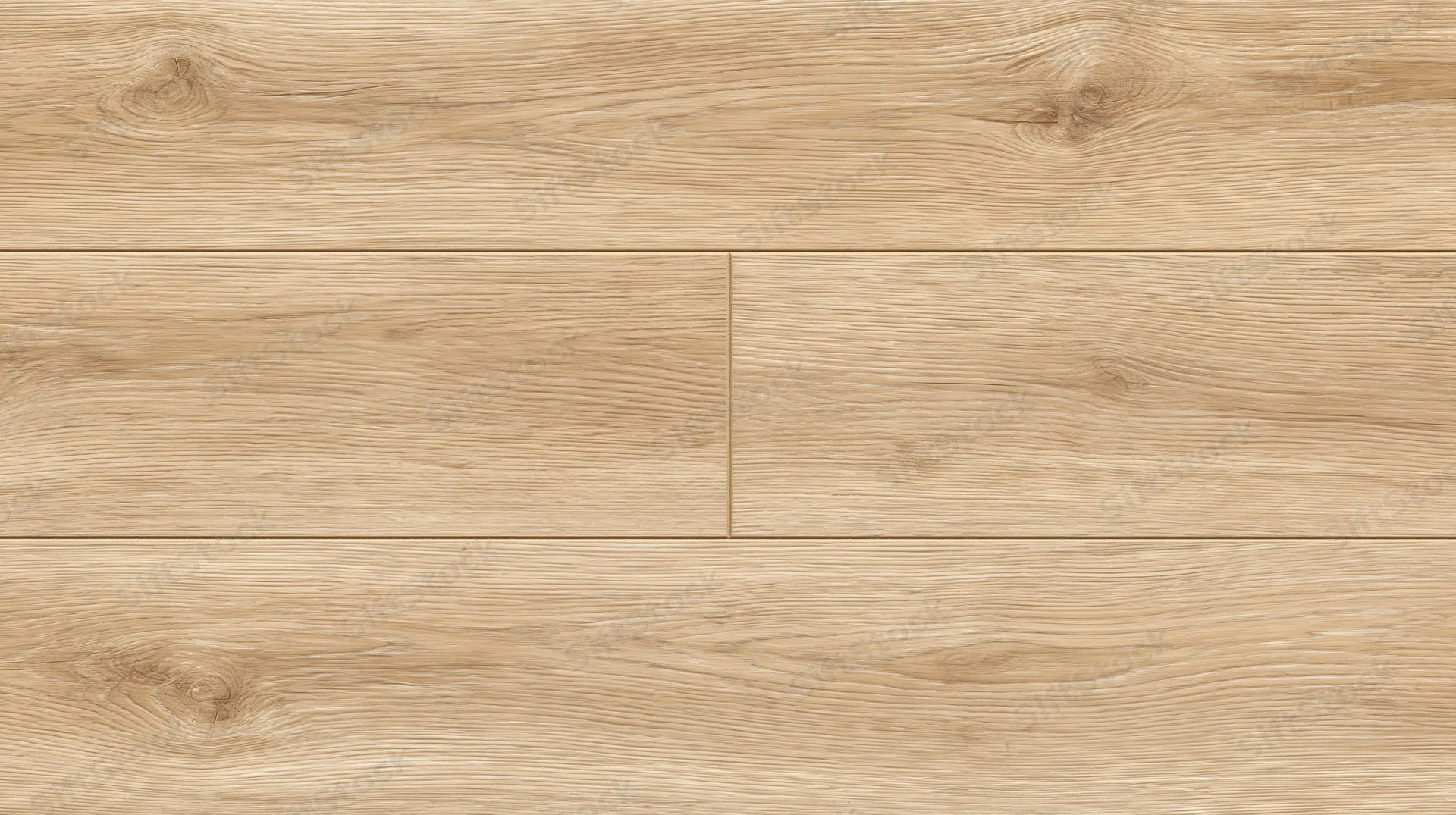 Close-up of light oak laminate flooring planks laid in a staggered pattern on a flat surface