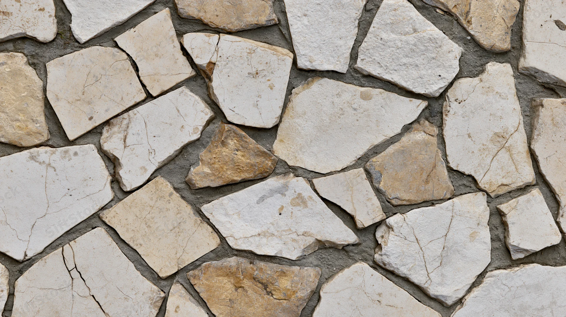Irregular broken limestone pieces arranged as mosaic pavement with gray mortar filling gaps