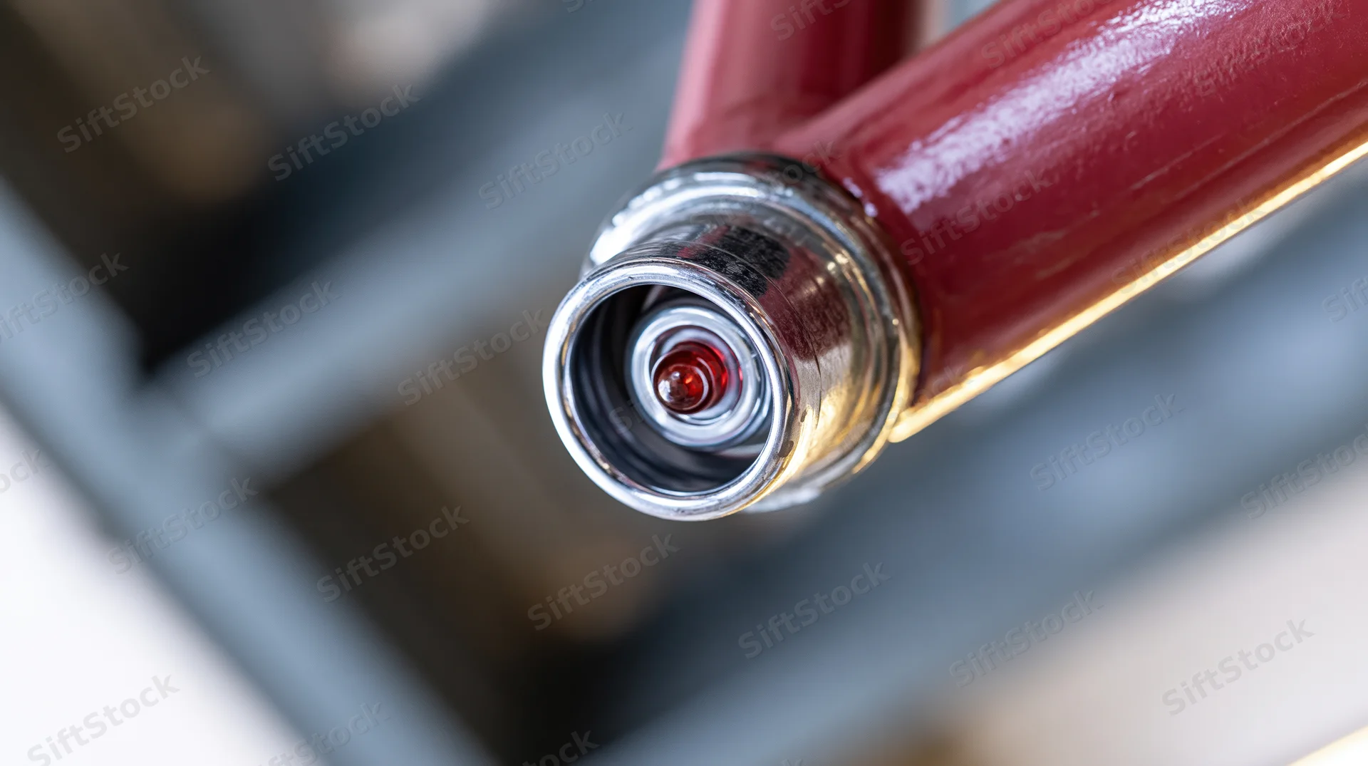 Close-up of a red fire suppression sprinkler head mounted on a ceiling pipe