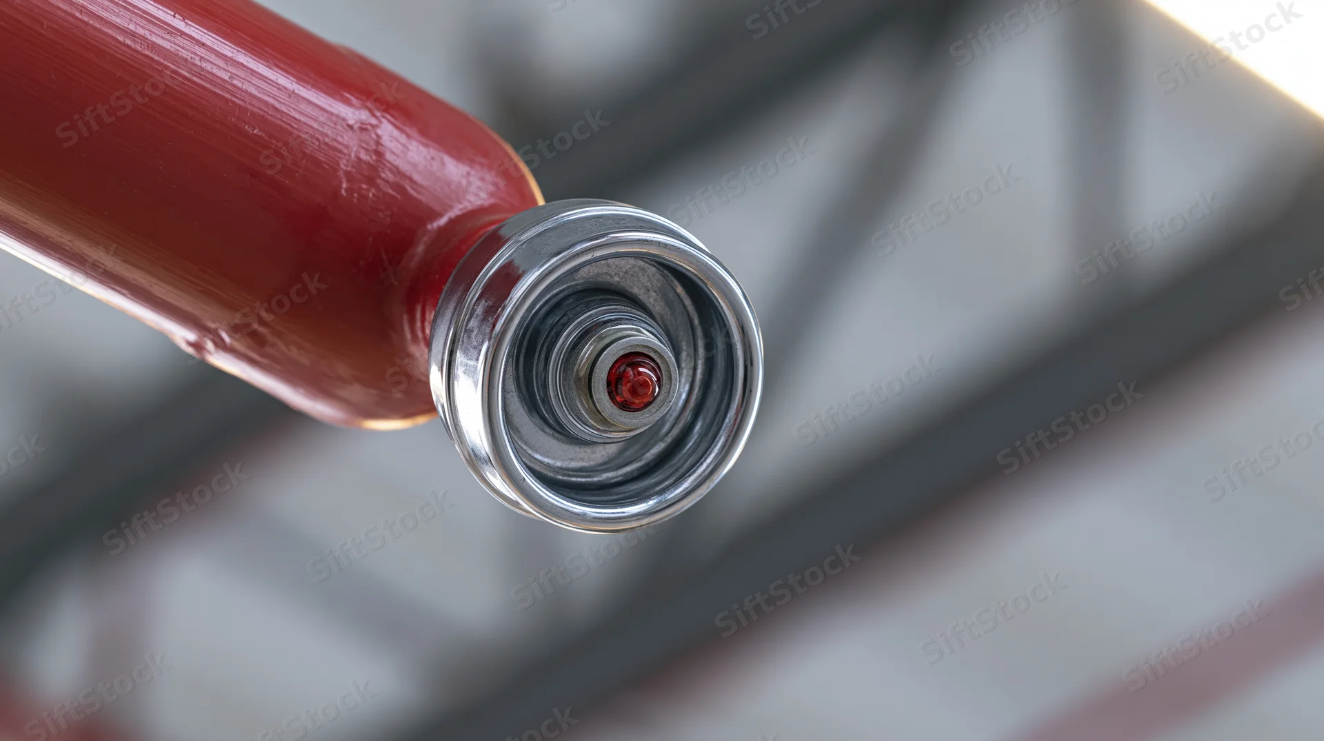 Close-up of a red fire suppression sprinkler head mounted on a ceiling pipe