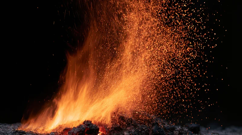 Flames bursting upward with sparks against dark background