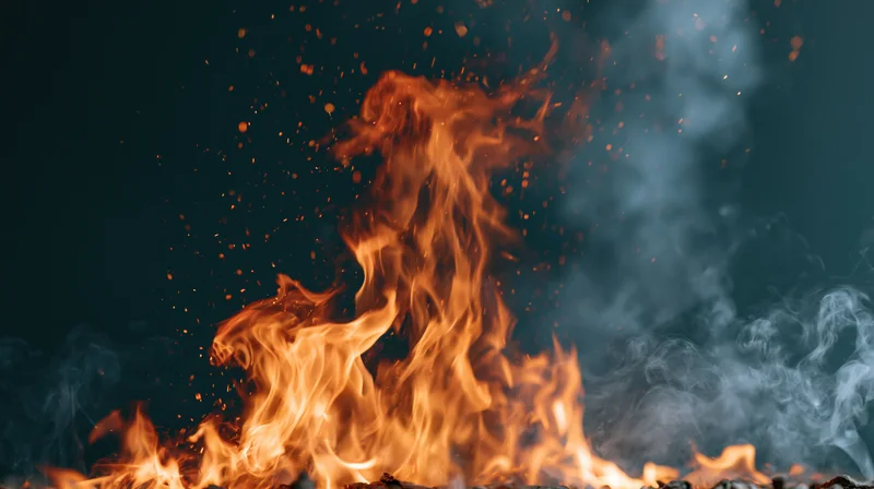 Intense flames rising with sparks and smoke against dark background
