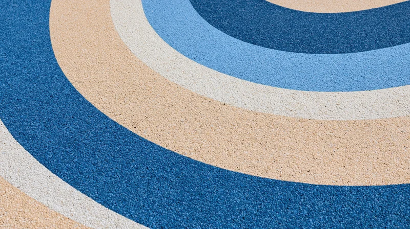 Close-up of blue beige and white circular patterned rubber playground surface