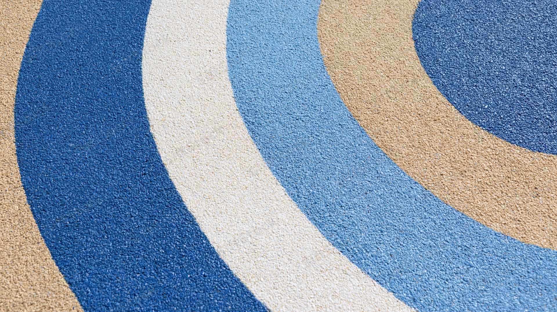 Close-up of blue beige and white circular patterned rubber playground surface