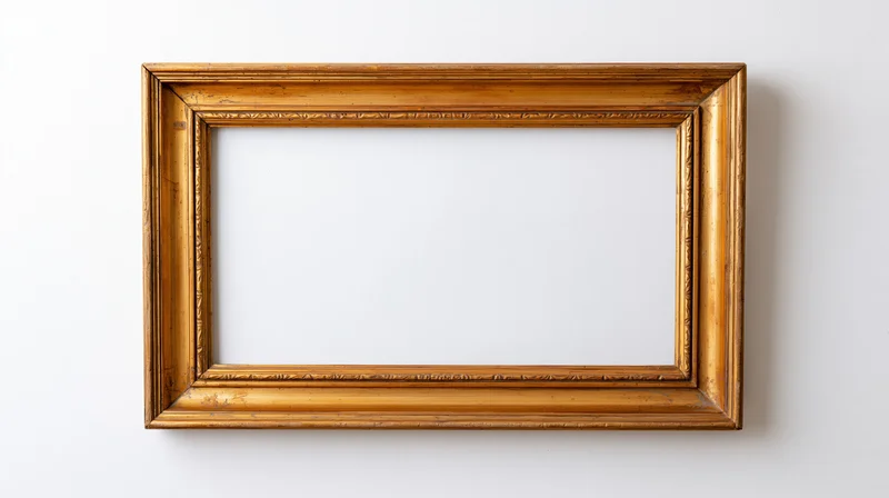 Empty antique gold picture frame with ornate molding hanging on a white wall