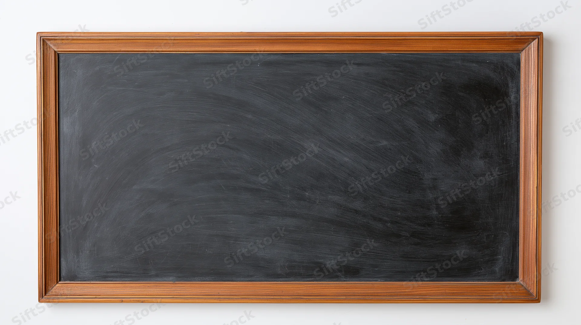 Empty blackboard with faint chalk smudges and eraser marks mounted on a white wall