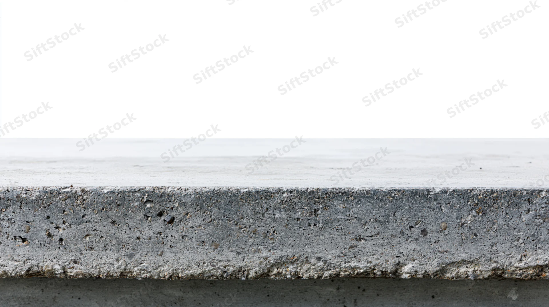 Flat concrete surface at eye level with rough edge and white background