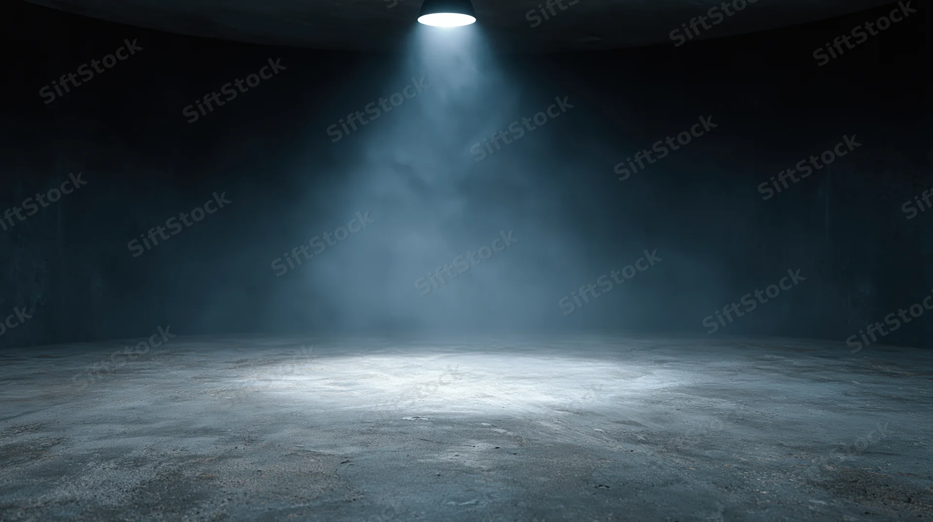Spotlight beam illuminating concrete floor in dark empty studio interior