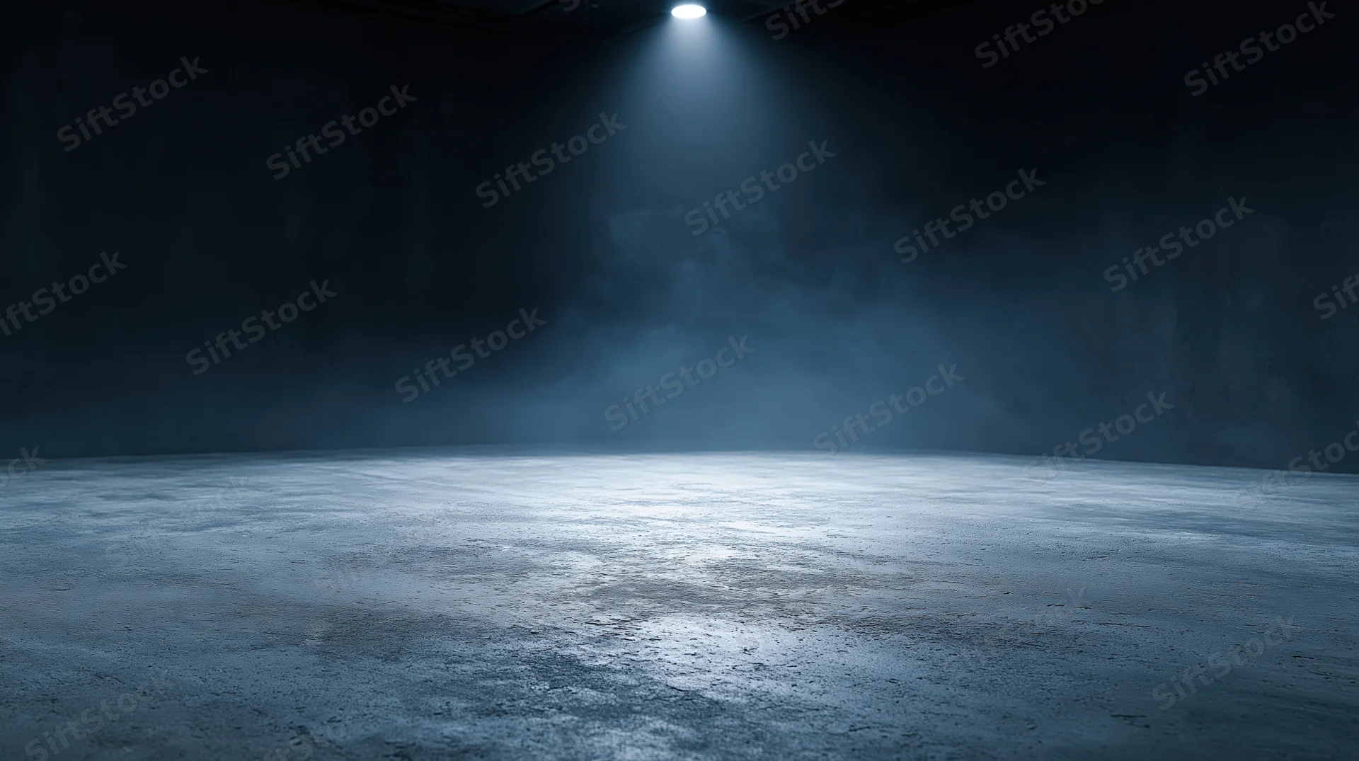 Spotlight illuminating a foggy concrete floor in a dark empty studio