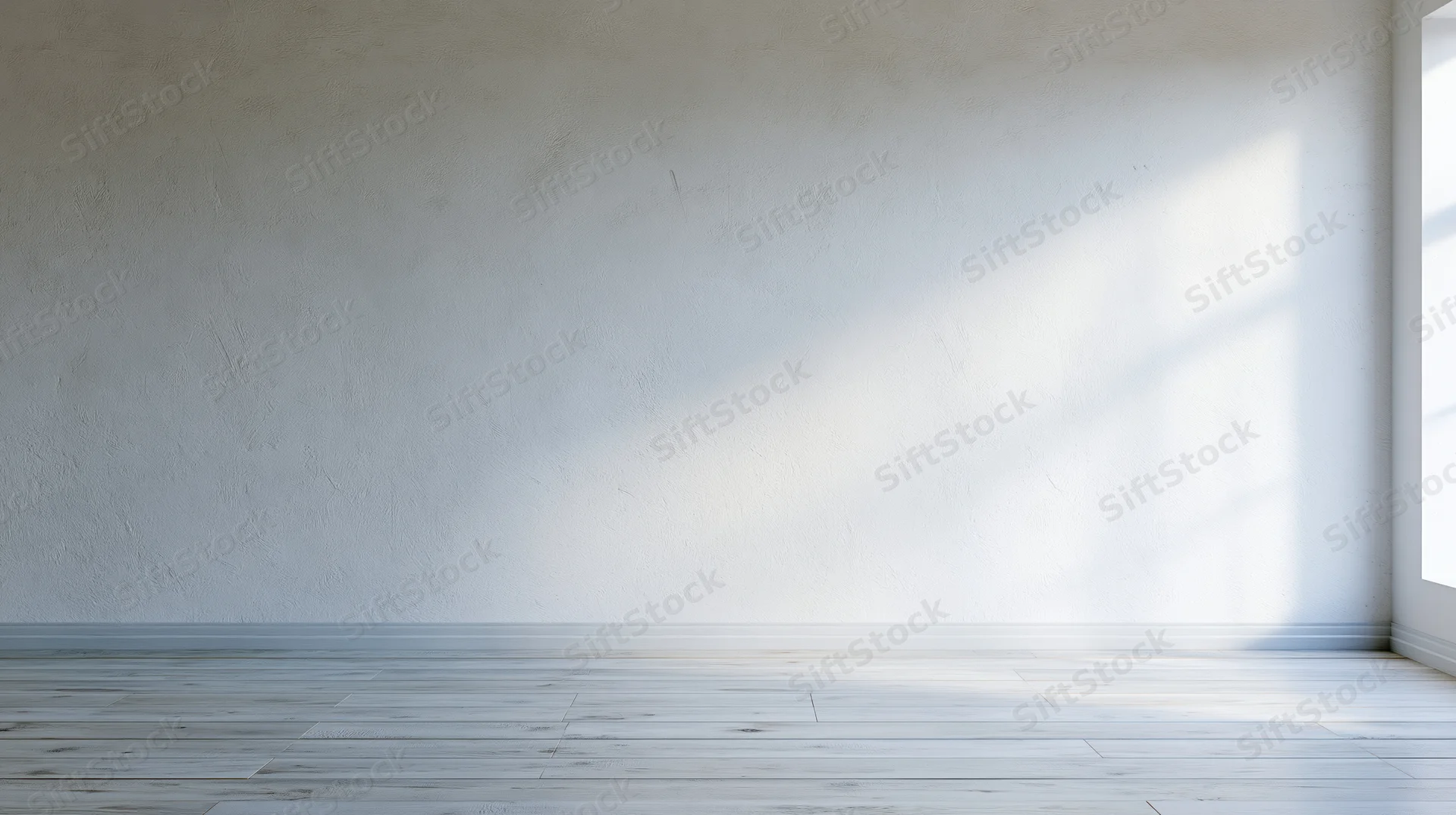 Empty room with white plaster wall and light wood floor, sunlight streaming through window