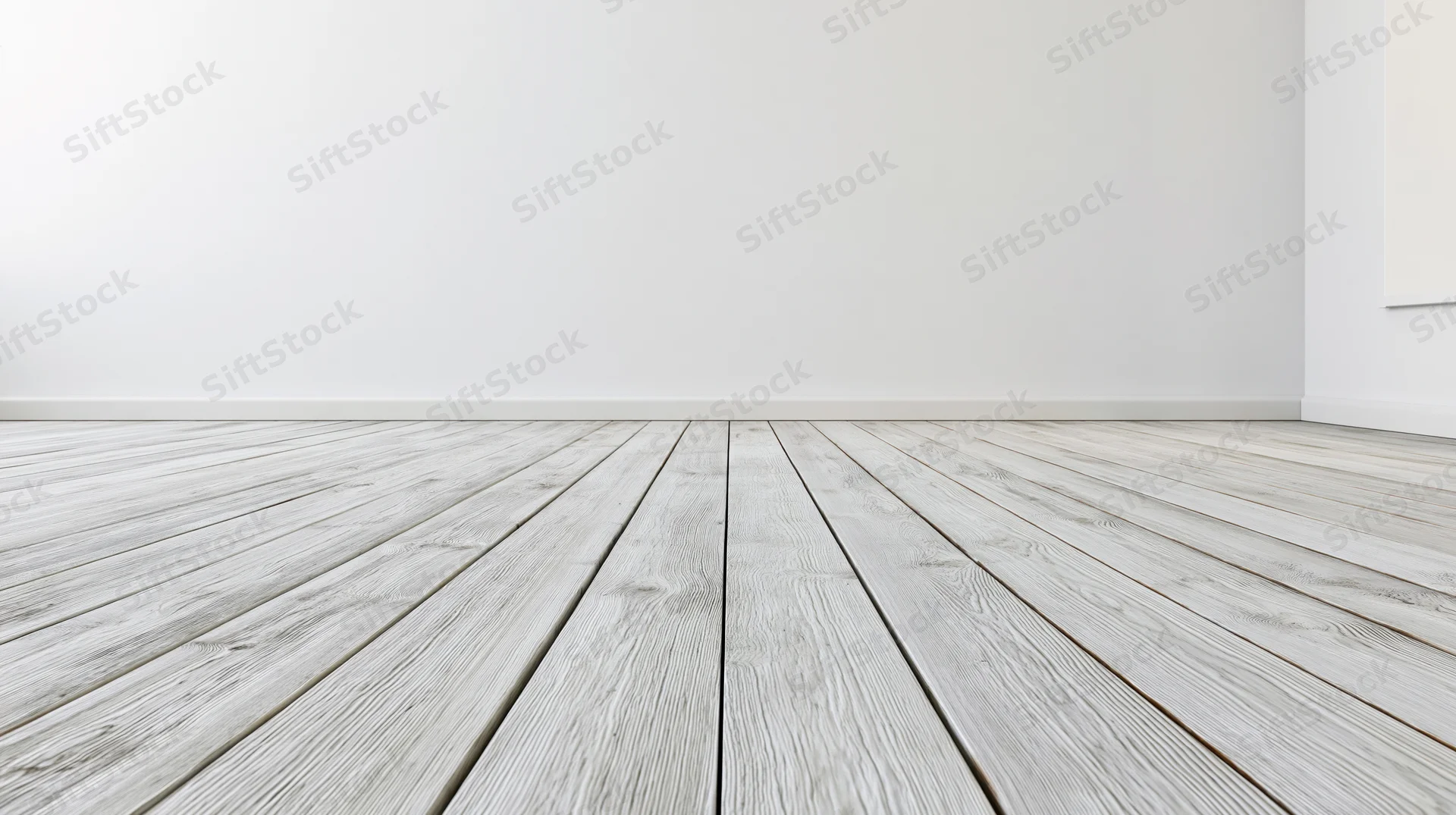 Empty room with whitewashed wooden plank floor receding into white walls