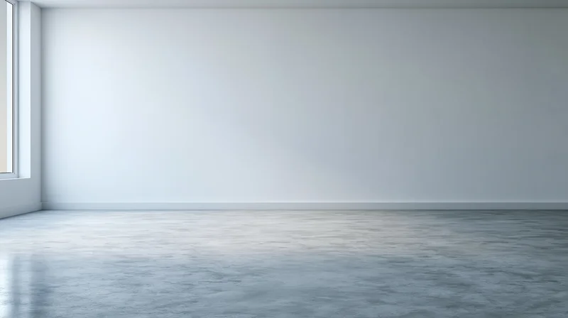 Empty minimalist room with white walls and concrete floor near a window