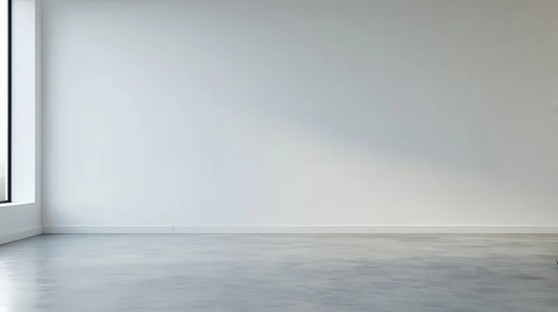 Empty minimalist room with white walls and concrete floor near a window
