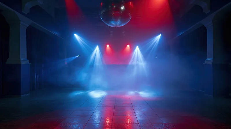 Empty nightclub dance floor illuminated by red and blue spotlights with a disco ball hanging above, surrounded by smoke and tiled flooring