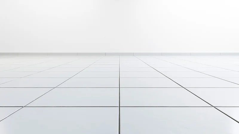 White ceramic tile floor receding into a plain white interior space