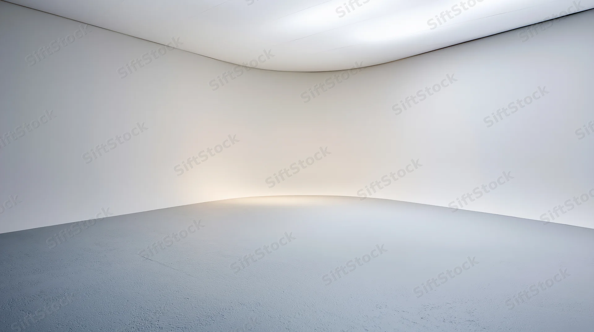 Empty white studio space with curved seamless walls and floor under bright ceiling light