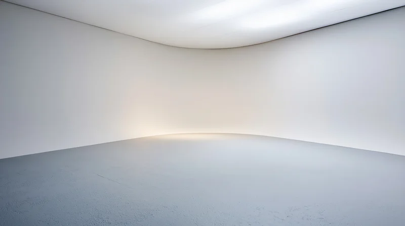 Empty white studio space with curved seamless walls and floor under bright ceiling light