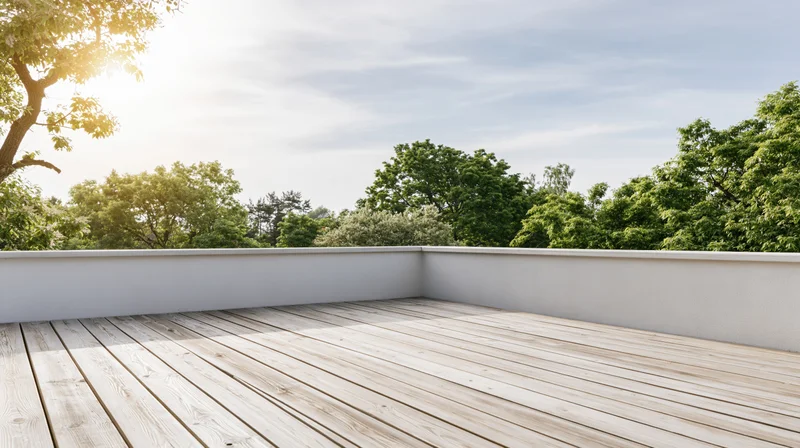 Empty wooden deck terrace with bleached planks and white walls overlooking green trees under a bright sky