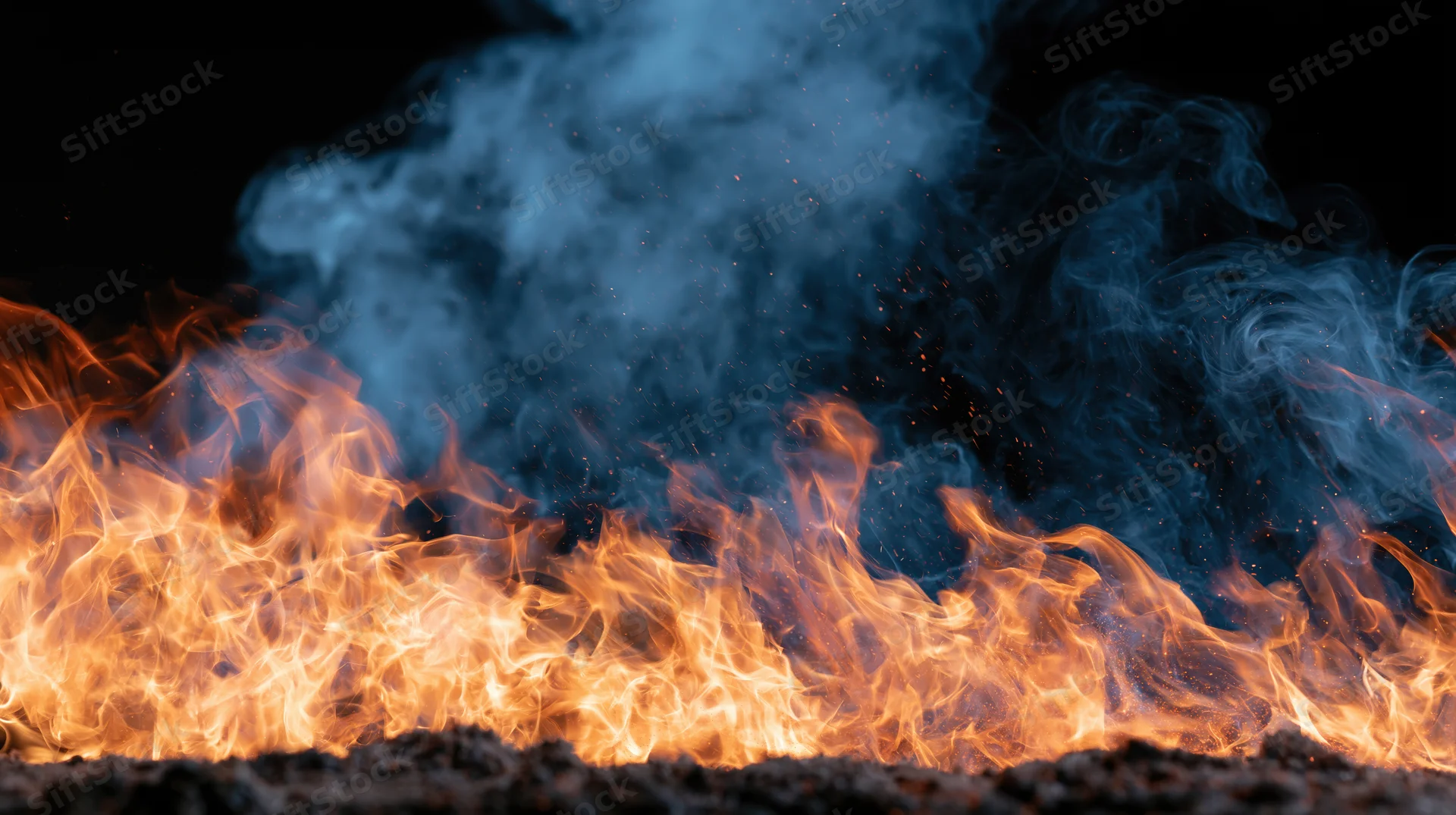 Flames burning intensely with blue smoke rising against a black background