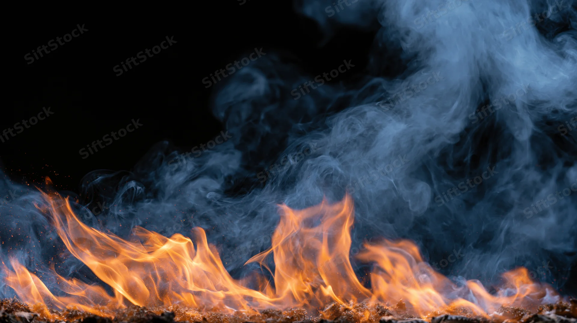 Flames and rising smoke against a black background