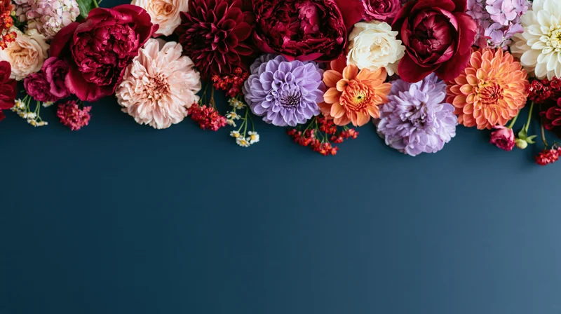 Mixed cut flowers arranged in a border along the top of a blue surface