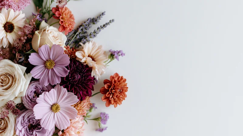 Mixed flowers arranged in a flat lay cluster on a white surface with copyspace