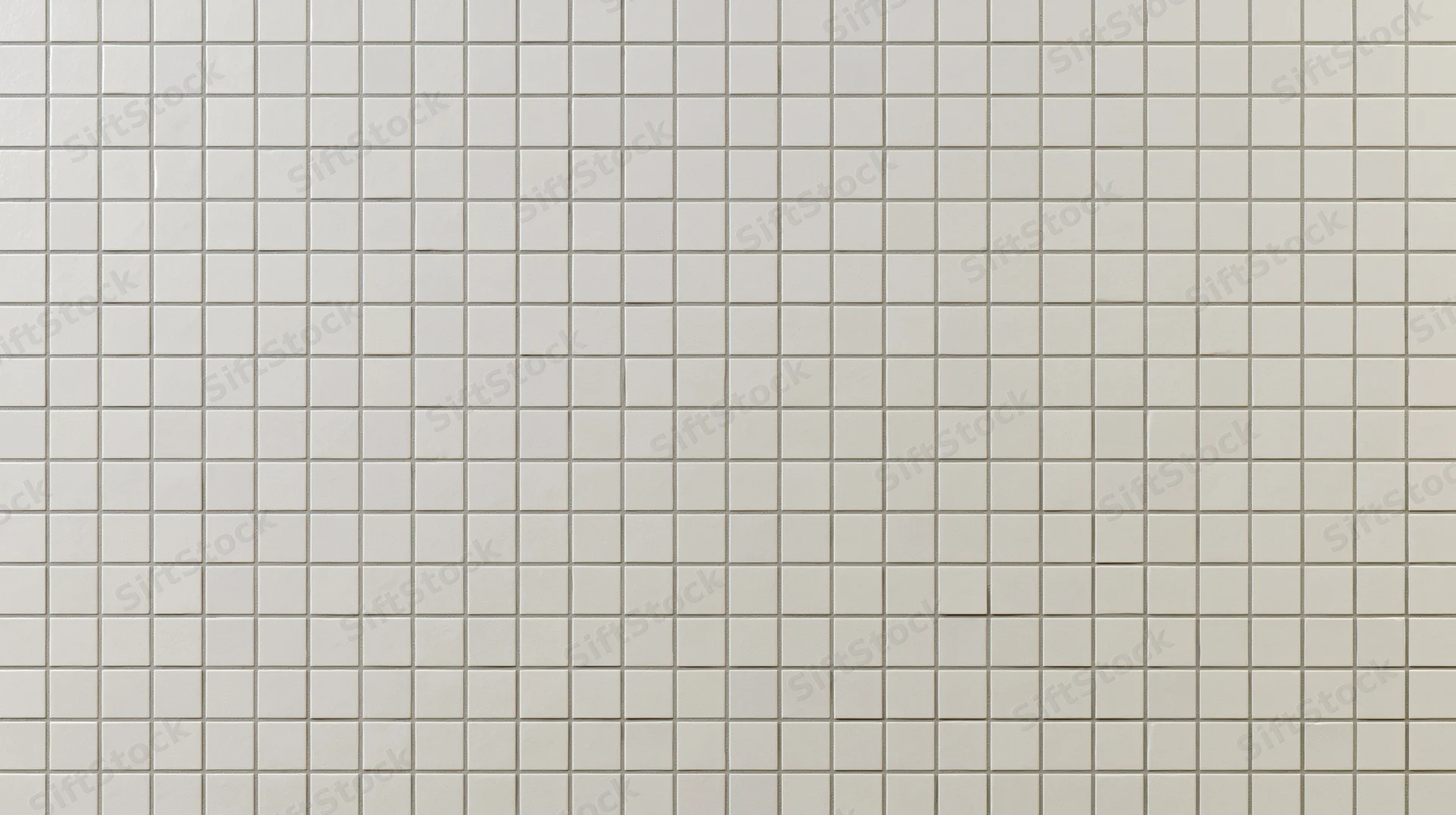 White ceramic square tiles arranged in a grid covering a wall