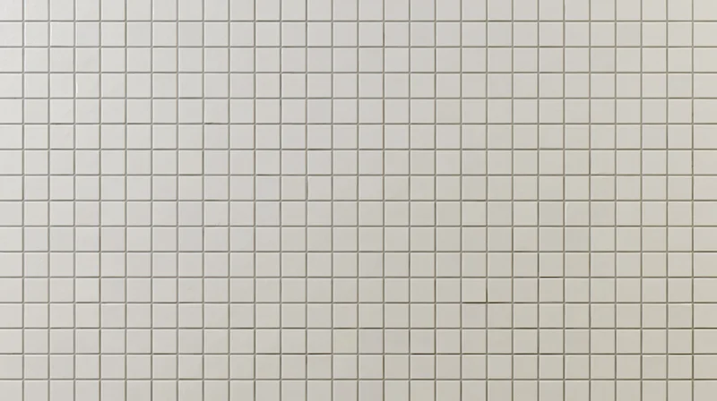 White ceramic square tiles arranged in a grid covering a wall